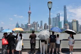 People standing underneath umbrellas during a heatwave in Shanghai, China.