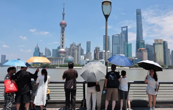 People standing underneath umbrellas during a heatwave in Shanghai, China.