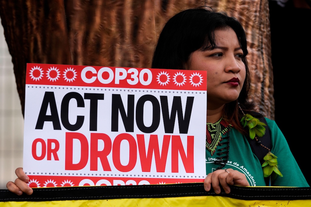 An Indigenous woman protests outside pre-COP30 meetings in Brasilia, Brazil. 